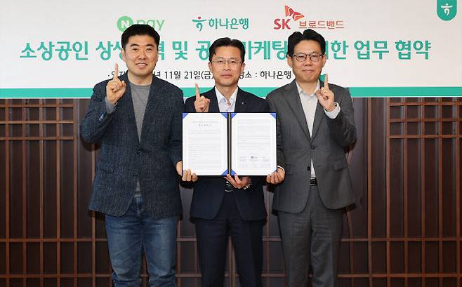 지난 21일 서울 을지로 하나은행 본점에서 하나은행이 네이버페이, SK브로드밴드와 함께 ‘소상공인 협력 생태계 구축을 위한 3자 업무협약’을 체결했다. 사진은 이날 협약식에 참석한 서유석 하나은행 기업그룹장(가운데)이 이향철 네이버페이 페이서비스 책임리더(왼쪽), 권정훈 SK브로드밴드 SOHO&SE 담당(오른쪽)과 함께 기념촬영을 하는 모습.(사진=하나은행)