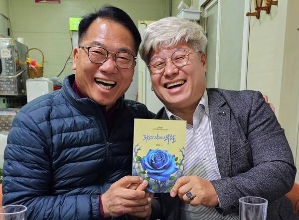 정현태(왼쪽) 전 남해군수가 10년 정치적 유배생활 소회를 기록한 책 <파란장미의 부활> 출판기념회에 앞서 지인에게 책을 선물하며 사진을 찍고 있다. /정현태 누리소통망