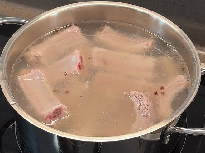 고기 냄새를 빼기 위해 등갈비를 초벌로 삶는 모습