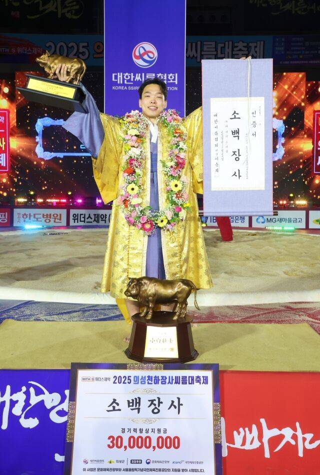 24일 경상북도 의성군 의성종합체육관에서 열린 ‘위더스제약 2025 의성천하장사씨름대축제’ 소백장사(72kg이하)에 등극한 임종걸(수원특례시청)이 장사인증서와 황소트로피를 들고 기념사진을 찍고 있다.