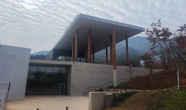 11개 기둥과 지붕 처마 아래 비워진 공간에서의 시선은 멀리 팔공산까지 확장한다.