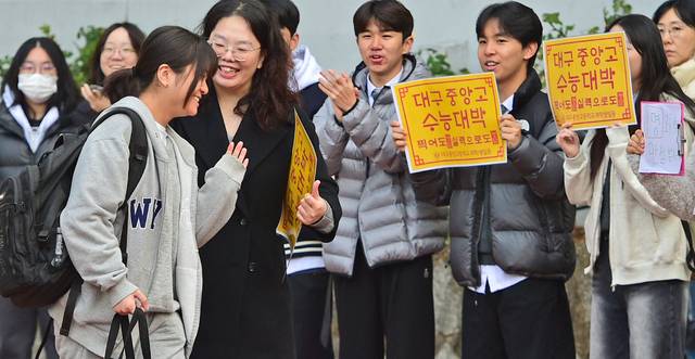 수능이 있었던 지난 13일 오전 대구여고에서 한 수험생이 교사·후배들의 응원을 받으며 시험장으로 향하고 있다. 김진홍 기자