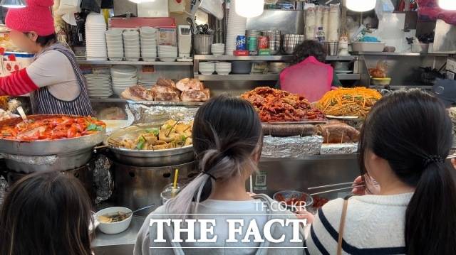 24일 오후 광장시장 내 노점에서 외국인 관광객이 음식을 먹고 있다. /이상빈 기자