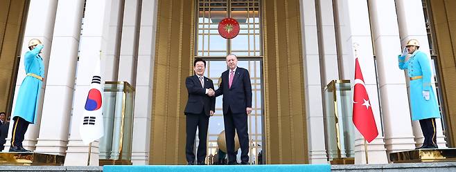 이재명 대통령이 24일(현지 시각) 앙카라 대통령궁에서 열린 국빈방문 공식 환영식에서 레제프 타이이프 에르도안 튀르키예 대통령과 악수하고 있다./연합뉴스