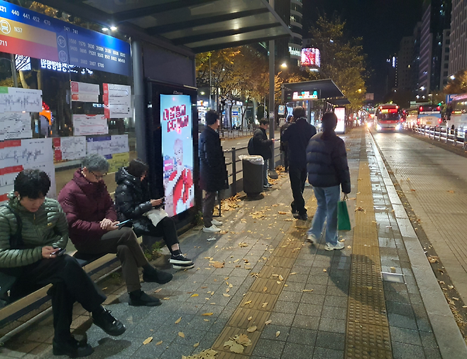 지난 20일 강남 서초구의 한 정류장에서 시민들이 일반의자에 앉아서 버스를 기다리고 있다. 사진=최승한 기자