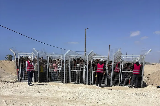 지난 5월, 가자 인도주의 재단(Gaza Humanitarian Foundation·GHF)이 식량 배급소 운영을 시작한 직후, 배급소 입장을 기다리며 철제 울타리 뒤에 서 있는 팔레스타인 주민들. 이 사진은 익명을 요구한 미국 계약업체 관계자가 제공했다. AP연합뉴스