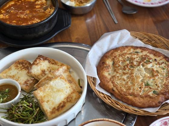 Pan-fried tofu in perilla oil and a pancake made out of soy pulp at Goduri [JIN EUN-SOO]