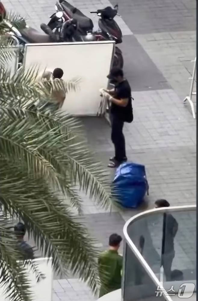 시신이 담긴 가방을 호찌민 한 아파트 입구에 버리고 용의자들이 도주했다.(베트남 플러스 제공. 재판매 및 DB 금지)2025.11.26/뉴스1