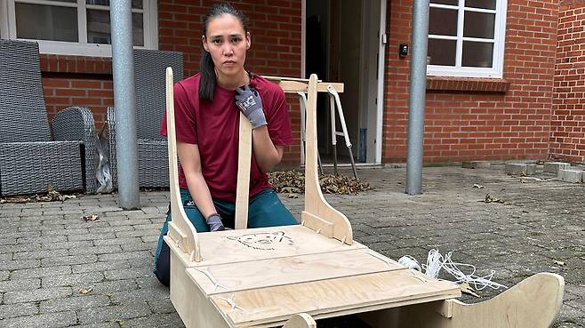 키이라는 딸 잠미의 첫 생일을 맞아 나무 썰매를 만들고 있다