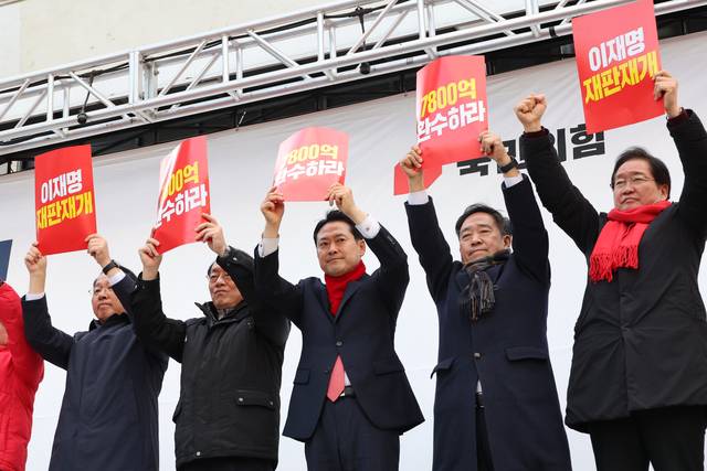 장동혁(오른쪽 세번째) 국민의힘 당대표가 26일 충남 천안종합버스터미널 조각광장에서 열린 ‘민생회복과 법치수호 충남 국민대회’에서 최고위원, 충남지역 의원, 당협위원장 등과 함께 손팻말을 들고 있다.