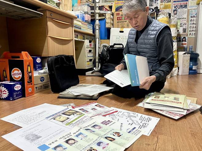 Na Ju-bong, head of the National Missing Children Search Citizens’ Coalition (translated), organizes missing-person posters, suspect flyers and tip letters related to the Frog Boys case at the group’s office in Dongdaemun District, eastern Seoul, on Nov. 25. [LEE AH-MI]