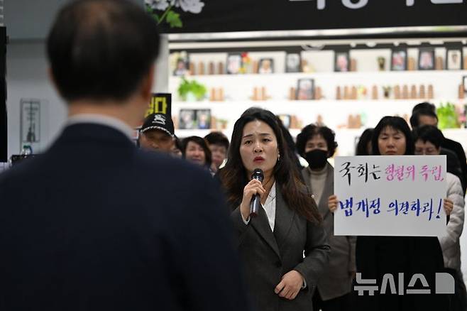 [무안=뉴시스] 이영주 기자 = 김유진(가운데) 12·29 무안공항 제주항공 여객기 참사 유가족 협의회 대표가 26일 오후 전남 무안군 무안국제공항에서 김윤덕 국토부장관을 향해 국토부 항공철도조사위원회가 예고한 참사 조사 결과 공청회 개최 중단을 촉구하고 있다. 2025.11.26. leeyj2578@newsis.com