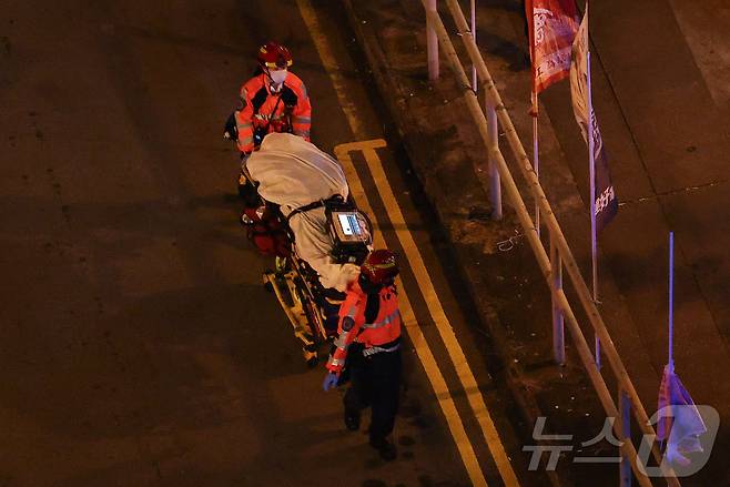 화재 현장에서 소방대원들이 사망자를 운구하고 있다. ⓒ 로이터=뉴스1 ⓒ News1 박형기 기자