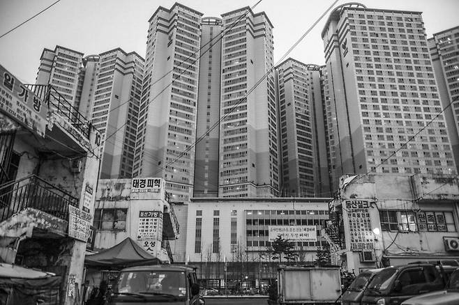 삼일아파트 자리에 들어선 성(뒤로 보이는 롯데캐슬 아파트) 앞에 잘린 채 일부 남아 있는 삼일아파트. 청계8가, 2013.