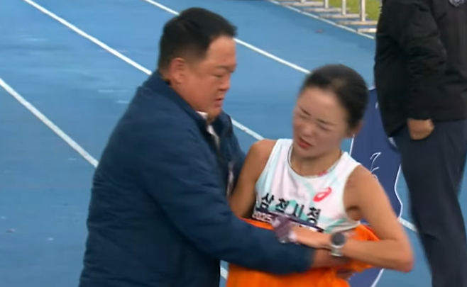지난 23일 2025 인천국제마라톤대회 여자부 경기서 결승선을 통과한 뒤 김완기 감독과 충돌한 이수민. 당시 이수민은 얼굴을 찌푸리며 감독의 손길을 밀쳤다. 사건 직후 감독의 성추행 논란으로 번졌는데, 선수는 이에 대해 선을 그으면서도 신체 접촉으로 인해 강한 통증을 느꼈다고 털어놨다. 선수는 감독에게 항의했으나, 아직 공식적 사과를 받지 못한 거로 알려졌다. 삼척시는 해당 안건에 대해 진상조사에 착수했다. 사진=KBS 중계화면 갈무리
