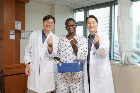 서울아산병원에서 대퇴골 재건 및 피부 이식 수술을 받은 존 콘테 씨(가운데)가 지난 13일 의료진과 기념사진을 찍고 있다. 왼쪽이 서울아산병원 정형외과 김지완 교수, 오른쪽이 성형외과 권진근 교수. 서울아산병원