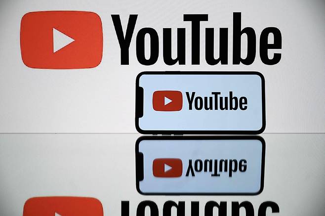 The YouTube logo is displayed on a tablet and smartphone. (AFP-Yonhap)