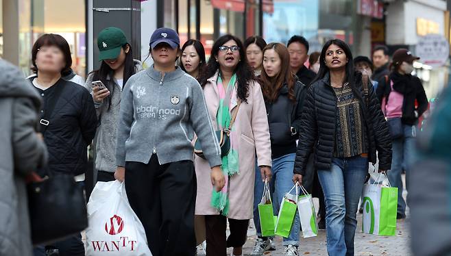 Foreign tourists enjoy shopping in Myeong-dong, central Seoul, on Nov. 13.  [NEWS1]