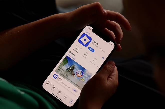 지난 19일(현지시간) 뉴질랜드 오클랜드에서 촬영된 이 사진 일러스트에서, 어린 아이들이 온라인 게임 플랫폼 로블록스(Roblox)를 사용하며 아이폰을 들고 있다. [게티이미지]