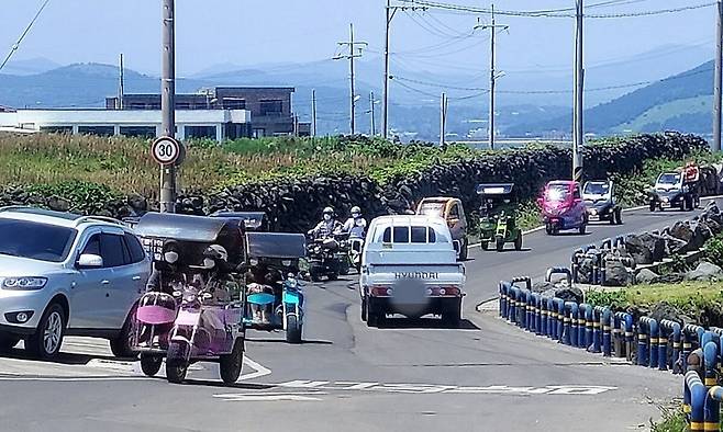 제주 우도 좁은 도로에 차량과 대여 삼륜차 등이 엉켜 혼잡한 모습을 보이고 있다. 제주=임성준 기자