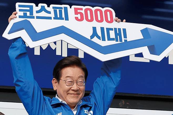 지난 5월 29일 이재명 당시 민주당 대통령 후보가  서울 고속버스터미널 광장에서 열린 유세에서 ‘코스피 5000시대’라고 적힌 피켓을 들고 있다./뉴스1