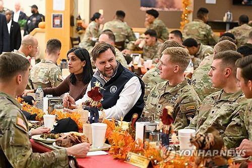 JD 밴스 미국 부통령과 그 부인 우샤 밴스가 2025년 미국 추수감사절 전날인 11월 26일켄터키주 포트캠벨 육군기지에서 병사들과 식사를 하고 있다. [포트캠벨(미국 켄터키주) AP=연합뉴스]