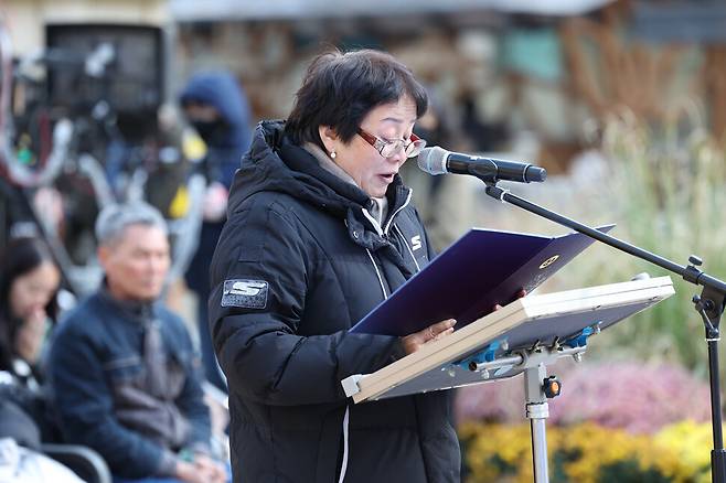 지난 18일 오후 서울 종로구 조계사에서 열린 산재사망 희생자 추모 위령재에서 몽골이주청년 고 강태완(타이왕)씨의 어머니 이은혜(엥크자르갈)씨가 유가족 대표로 발원문을 읽고 있다. 뒤쪽에 고 뚜안씨의 아버지가 앉아 있다. 김영원 기자 forever@hani.co.kr