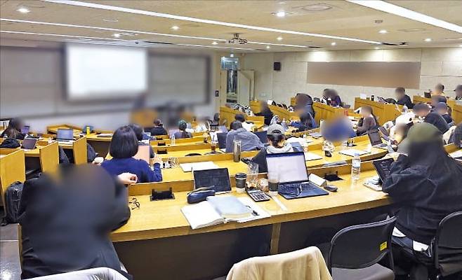 지난 21일 서울의 한 대학 강의실에서 학생들이 전공 수업을 듣고 있다. 상당수가 노트북을 펼쳐둔 채 휴대폰을 보거나 책상에 엎드려 있다. /김유진 기자