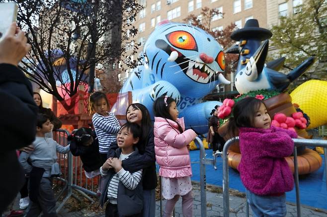 지난 26일(현지시간) 더피와 서씨 풍선 앞에서 사진을 찍기 위해 포즈를 취하고 있는 아이들. /사진=로이터