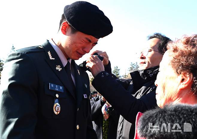 [광주(경기)=뉴시스] 김종택기자 = 28일 경기 광주시 오포읍 육군 특수전학교에서 열린 '특전부사관 261기 임관식'에서 한 특전부사관 가족들이 계급장을 달아주고 있다. 2025.11.28. jtk@newsis.com