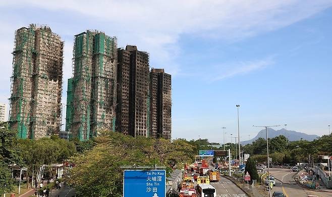 ▲ 지난 28일(현지시간) 화재가 완전히 진압된 홍콩 북부 타이포의 고층 아파트 단지 웡 푹 코트 앞 도로에 경찰차와 소방차가 주차돼 있는 모습. /연합뉴스