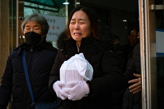 김유진 유가족협의회 대표가 지난 1월 6일 광주 북구 광주영락공원에서 화장을 마치고 나온 가족의 유골함을 들고서 오열하고 있다. 김 대표는 참사로 부모님과 남동생을 한꺼번에 잃었다. 광주=하상윤 기자