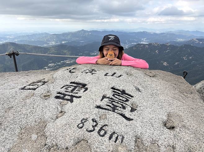 Melanie Hingpit from the Philippines poses with a stuffed animal representing a Stray Kids member at the summit of Bukhansan National Park in Seoul during her October hike. (Melanie Hingpit)