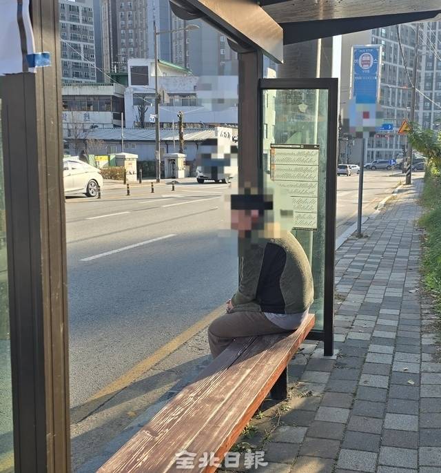 나무 의자에 앉아 버스를 기다리고 있는 시민. /김문경 기자