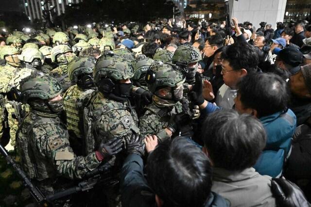 지난해 12월3일 밤 윤석열 당시 대통령이 비상계엄을 선포한 뒤 군인들이 서울 영등포구 국회의사당에서 진입을 시도하고 있다. 연합뉴스