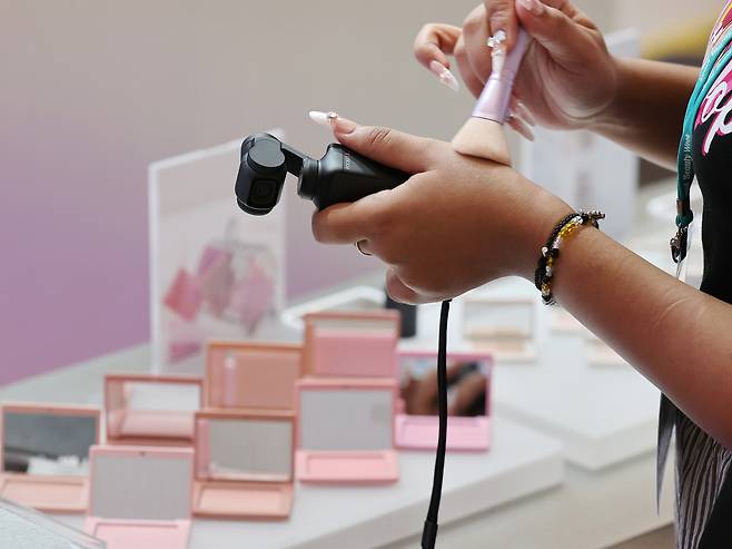 In this photo unrelated to the story, a visitor tests cosmetics at a booth during the 2025 Seoul Beauty Week at Dongdaemun Design Plaza in Jung District, Seoul, on Aug. 28. [YONHAP]