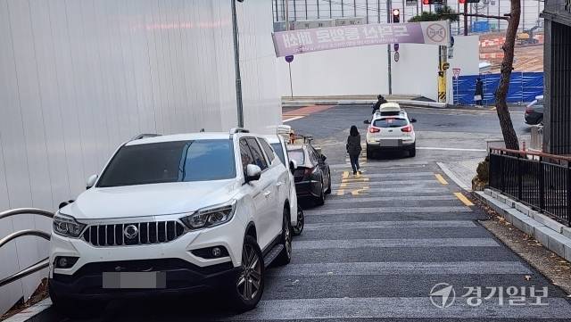 광명시 철산동 철산역 인근 재개발구역 경사길 이면도로에 주차된 차량 뒤로 주민 1명이 지나가고 있다. 한준호기자