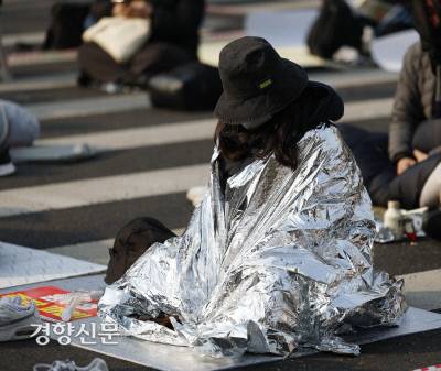 윤석열 대통령 탄핵심판 선고일인 4일 서울 종로구 안국역 인근에서 ‘윤석열 8대0 파면을 위한 끝장 대회’ 밤샘 집회 참가자가 방한용 은박 비닐을 덮은 채 자리를 지키고 있다. 문재원 기자