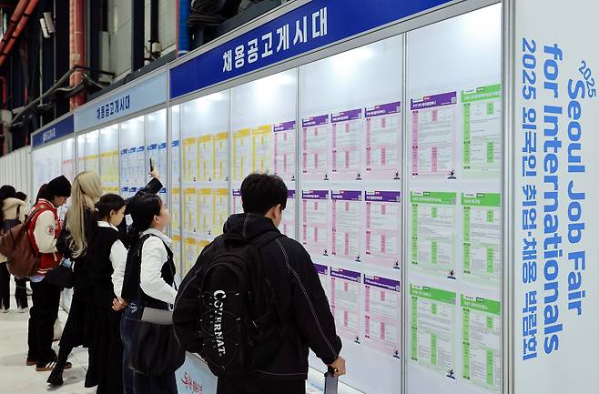 Job seekers read notices for positions on bulletin boards at a job fair held at Setec in Gangnam District, southern Seoul on Nov. 20. [NEWS1]