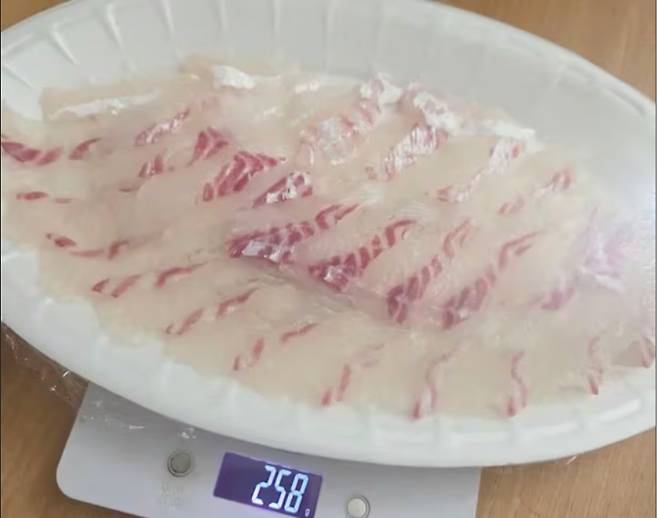 지난 달 29일 유튜브 '입질의추억TV'에 소개된 참돔회. 참돔회의 무게가 전자저울에 258g로 표시돼 있다. 제보자는 "2kg를 주문했는데 회접시를 포함한 무게가 258g이었다"고 주장했다. 유튜브 캡처