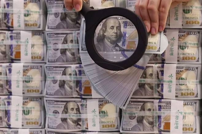 서울 중구 명동 KEB하나은행 위변조대응센터에서 직원이 미국 달러를 들어 보이고 있다. 연합뉴스