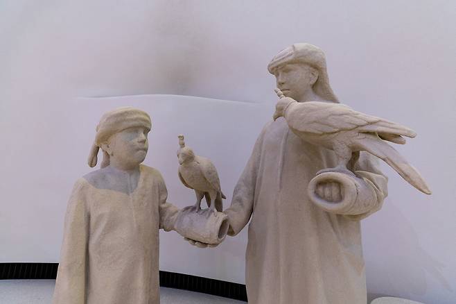Statues of falconers displayed inside the "To Our Roots" gallery at the Zayed National Museum [ZAYED NATIONAL MUSEUM]