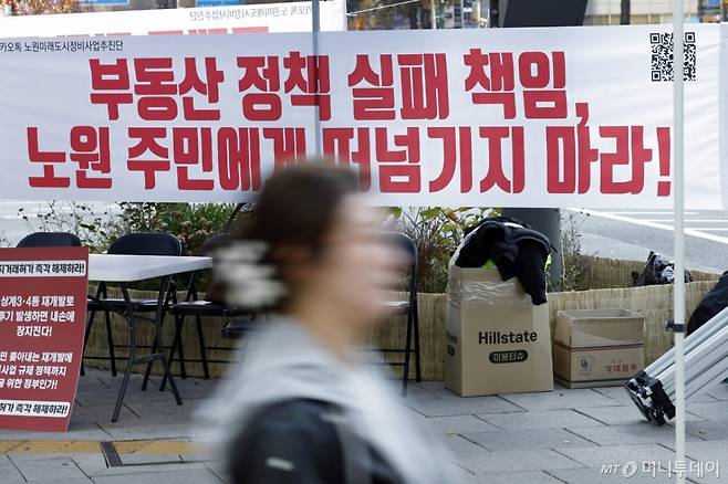 (서울=뉴스1) 박정호 기자 = 22일 오후 서울 노원구 롯데백화점 사거리에 붙은 토허제 규탄 플래카드 앞으로 구민들이 지나고 있다.  2025.11.22/뉴스1  Copyright (C) 뉴스1. All rights reserved. 무단 전재 및 재배포,  AI학습 이용 금지. /사진=(서울=뉴스1) 박정호 기자