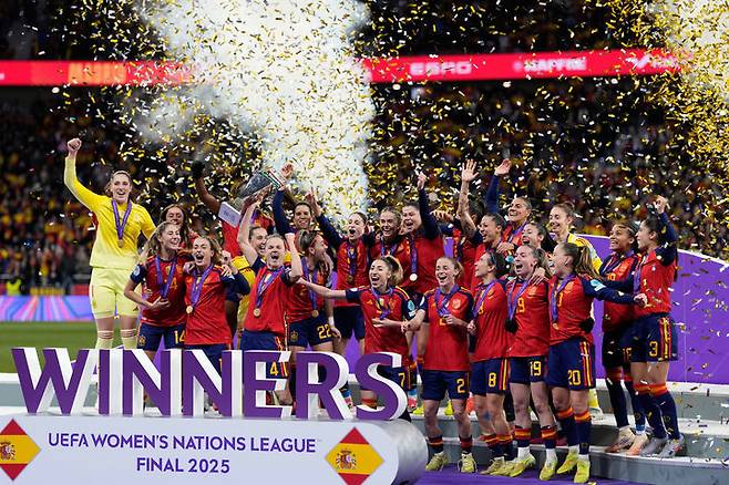 [마드리드=AP/뉴시스] 스페인 선수들이 2일(현지 시간) 스페인 마드리드 에스타디오 메트로폴리타노에서 열린 2025 유럽축구연맹(UEFA) 여자 네이션스리그 정상에 올라 트로피를 들고 환호하고 있다. 스페인은 결승 2차전에서 독일을 3-0으로 꺾어 합산 점수 3-0으로 승리하며 대회 2연패를 달성했다. 2025.12.03.