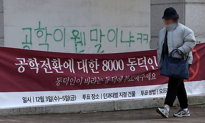 동덕여자대학교 공학 전환 타당성에 대한 외부 용역 결과 발표와 '공학 전환에 대한 8000 동덕인 의견 조사' 학생 총투표가 실시되는 3일 서울 성북구 동덕여대에서 한 학생이 총투표 관련 현수막 앞을 지나가고 있다. 뉴시스