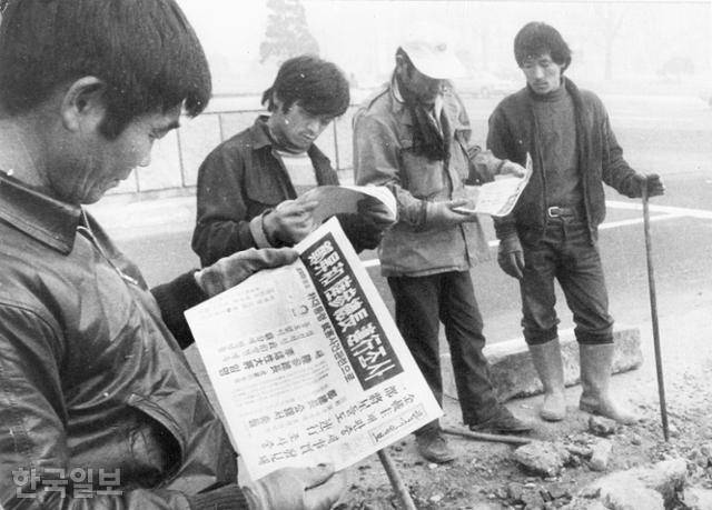 작업장의 노동자들이 1979년 12월 14일 자 한국일보 1면을 읽고 있다. 당시 한국일보를 포함한 언론들은 12·12 군사반란의 전말을 보도하는 대신 반란 세력에 포섭된 노재현 국방 장관이 발표한 내용을 그대로 받아썼다. 한국일보 자료사진