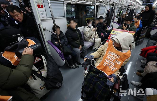 [서울=뉴시스] 이영환 기자 = 전국장애인차별철폐연대(전장연) 회원들이 4일 오전 서울 종로구 지하철5호선 광화문역에서 열린 '제67차 출근길 지하철 탑니다’ 시위에 참석하기 위해 5호선에 탑승해 광화문역에 도착하고 있다. 2025.12.04. 20hwan@newsis.com