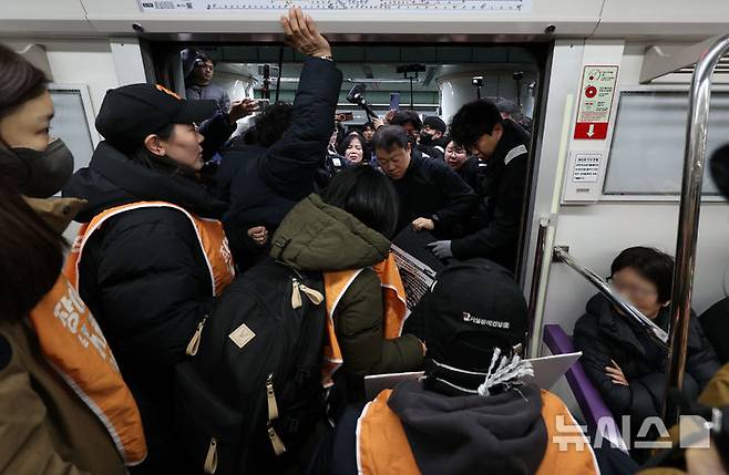 [서울=뉴시스] 이영환 기자 = 전국장애인차별철폐연대(전장연) 회원들이 4일 오전 서울 종로구 지하철5호선 광화문역에서 열린 '제67차 출근길 지하철 탑니다’ 시위에 참석하기 위해 5호선에 탑승해 광화문역에 도착해 안전발판 교체를 요구하고 있다. 2025.12.04. 20hwan@newsis.com