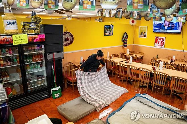 2일(현지시간) 뉴올리언스 가족 운영 식당 내부에 간이 침대 만드는 여성 [뉴올리언스 로이터=연합뉴스. 재판매 및 DB 금지]