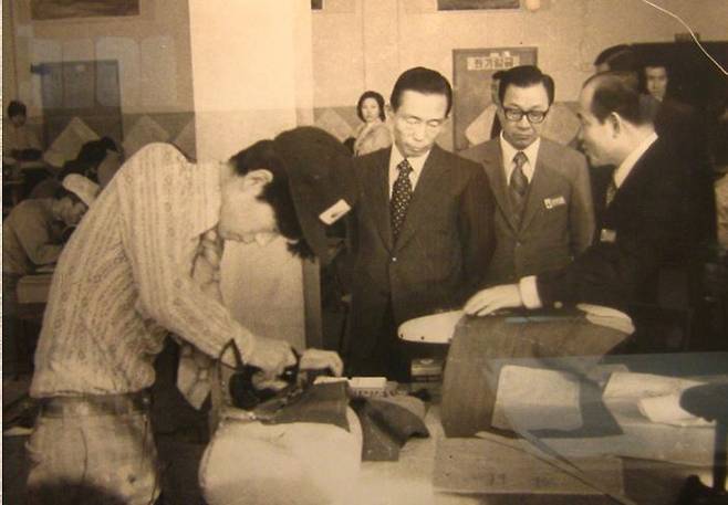 1974년 전국기능경기대회 박정희 대통령과 백 명장 1974년 열린 전국기능경기대회에서 박정희(오른쪽서 3번째) 대통령이 지켜보는 가운데 양복을 재단하고 있는 백운현(왼쪽) 명장. [백운현 명장 제공]